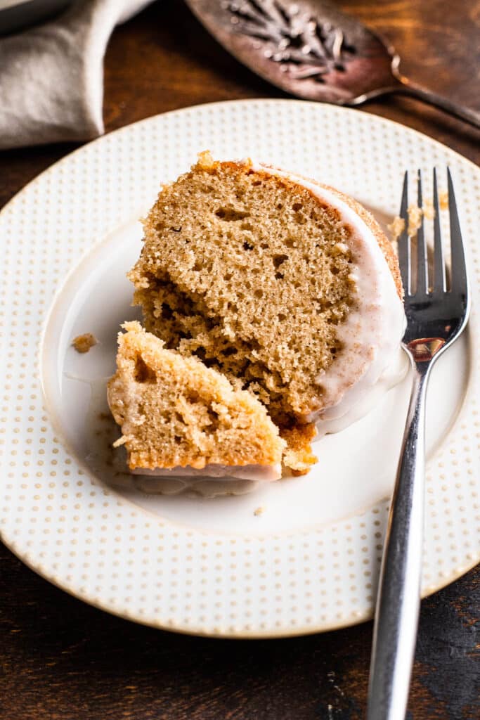 A slice of apple cider bundt cake with glaze on a plate 