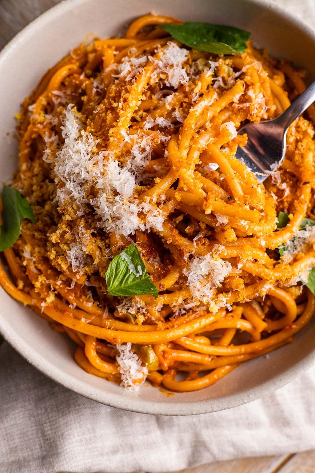 A bowl of caramelized shallot pasta topped with a heap of Parmesan. 