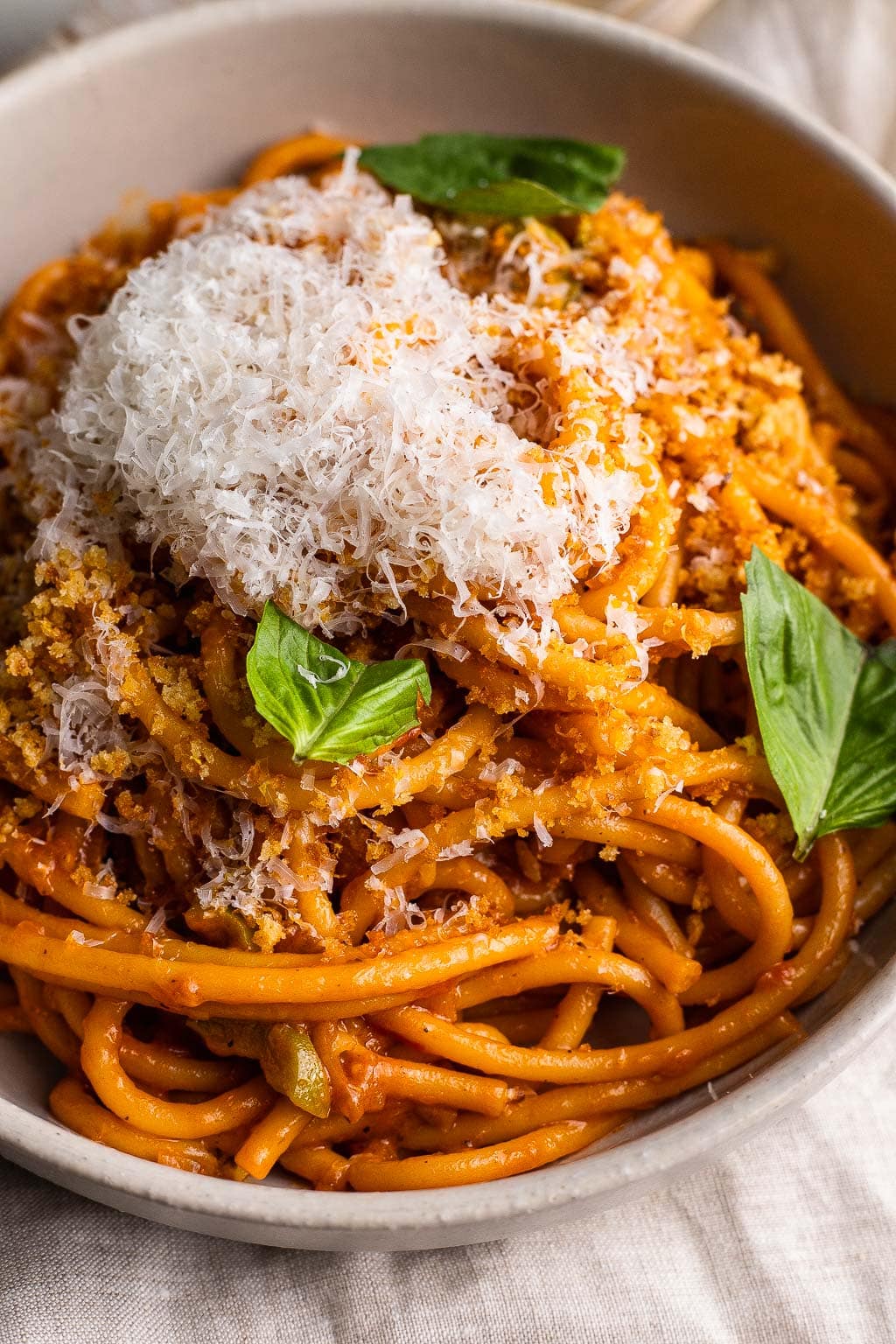 A bowl of caramelized shallot pasta topped with a heap of Parmesan. 