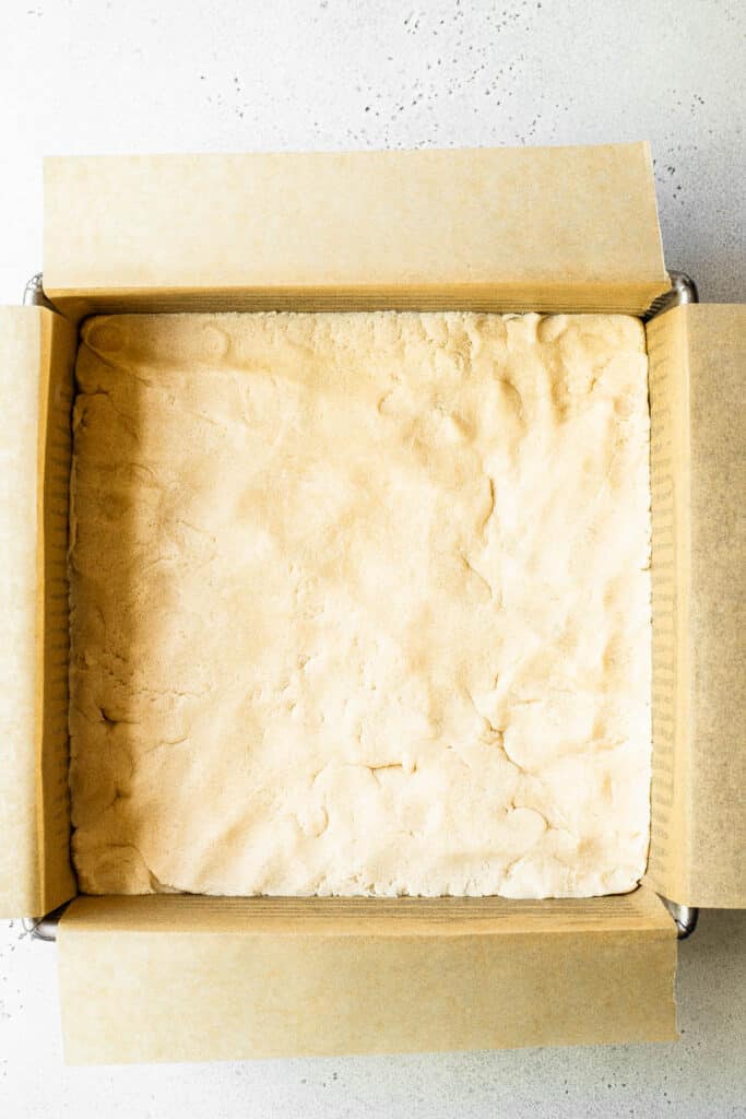 Shortbread crust pressed into a lined baking dish