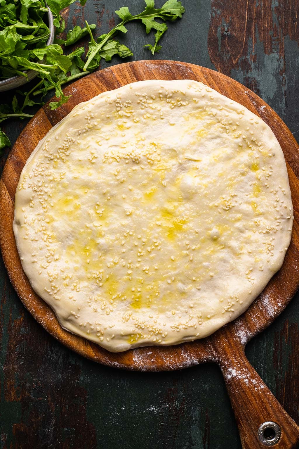 A pizza crust topped with garlic oil. 