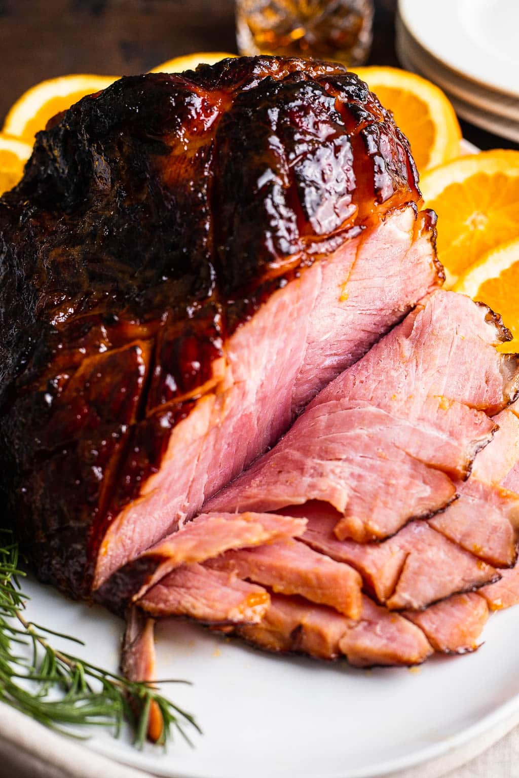 Close up view of a glazed ham, sliced on a platter 