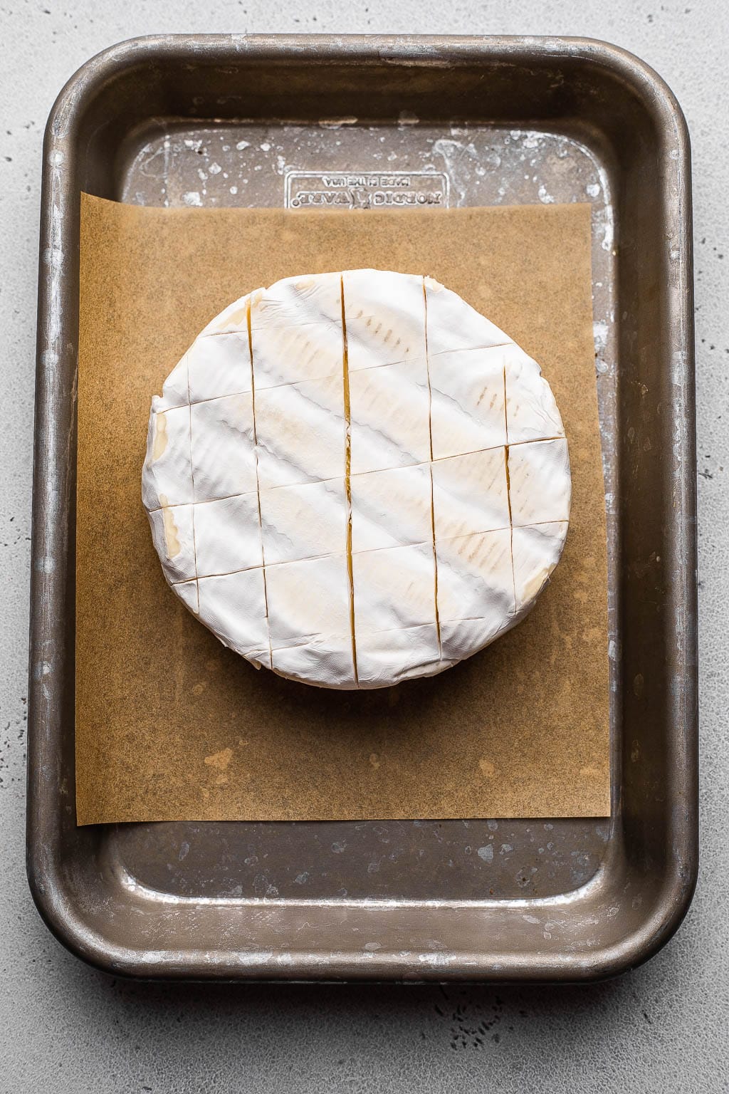 A scored wheel of brie cheese 