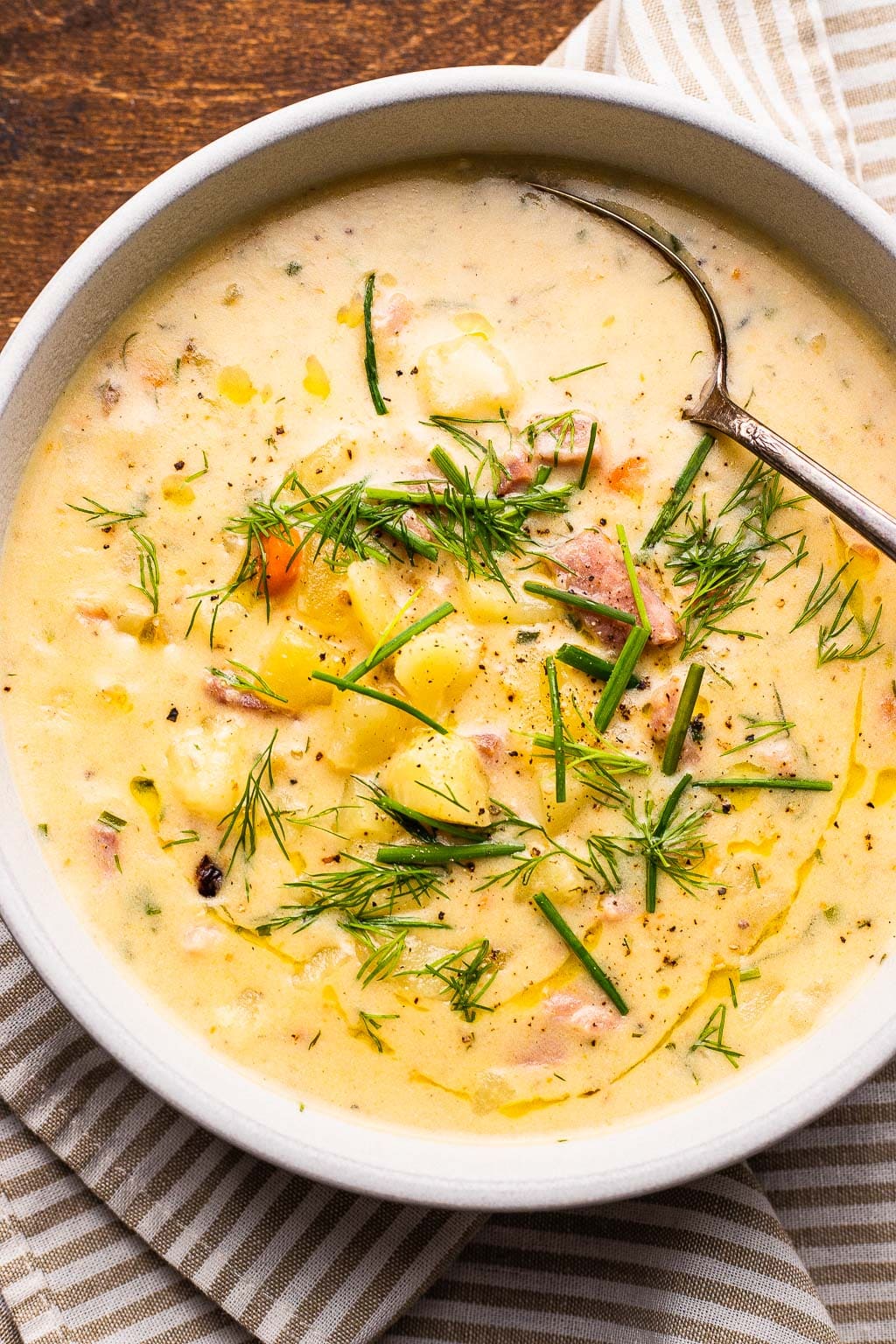 A bowl of leftover ham and potato soup topped with fresh dill 