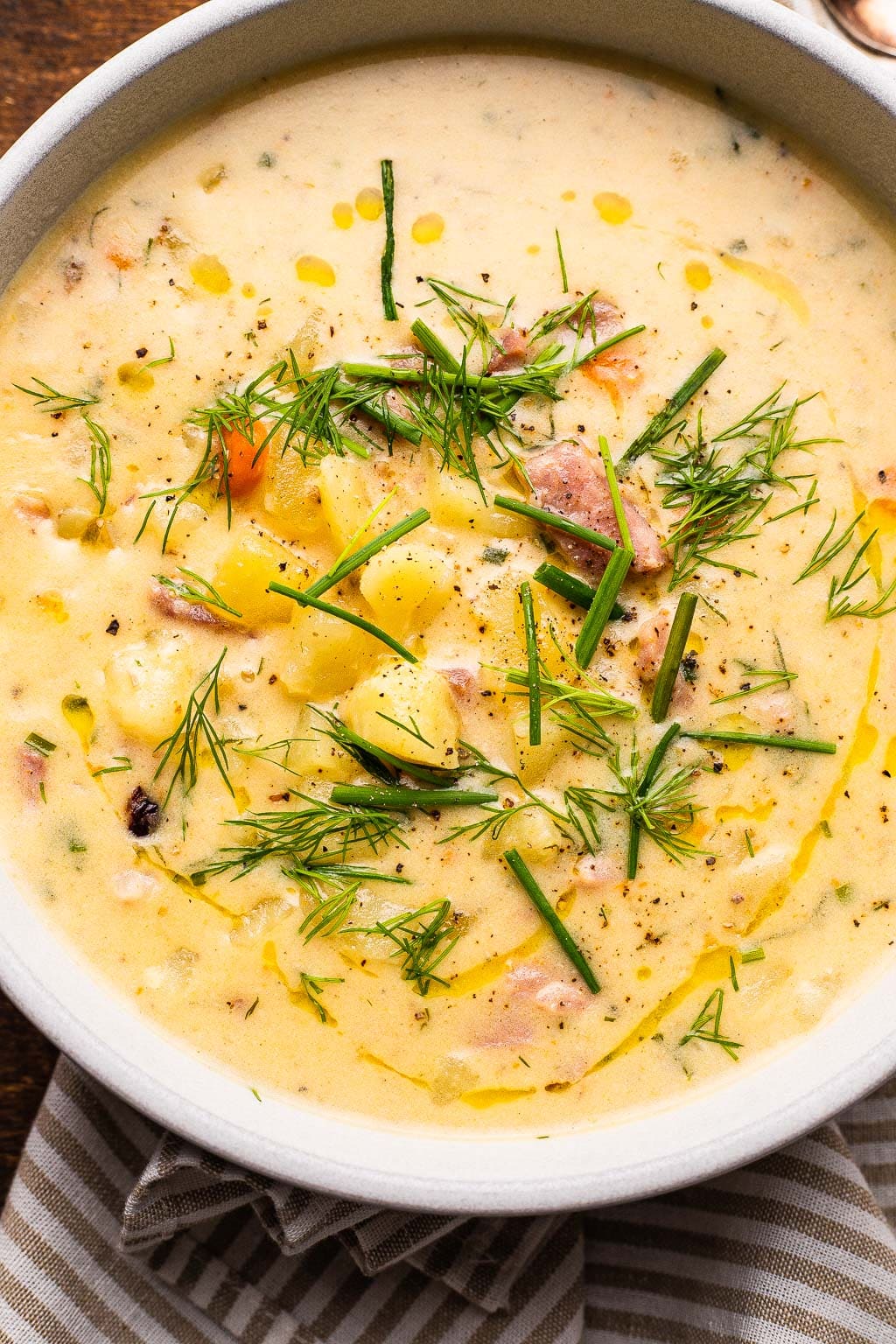 A bowl of leftover ham and potato soup topped with fresh dill 
