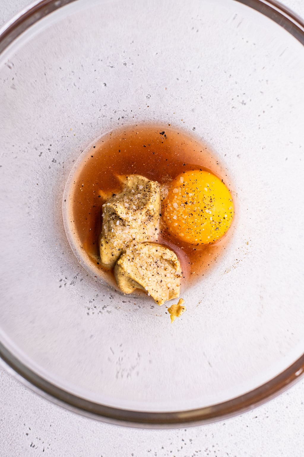 Vinegar, egg yolk, and Dijon in bowl