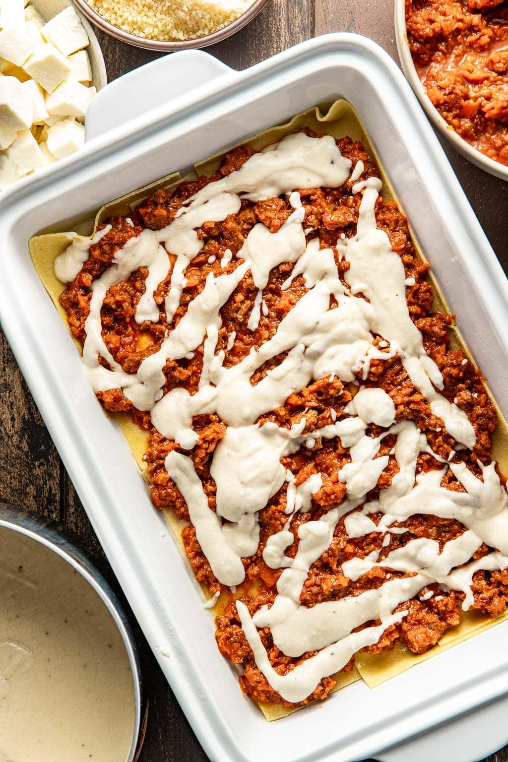 Layering cheese onto a lasagna. 