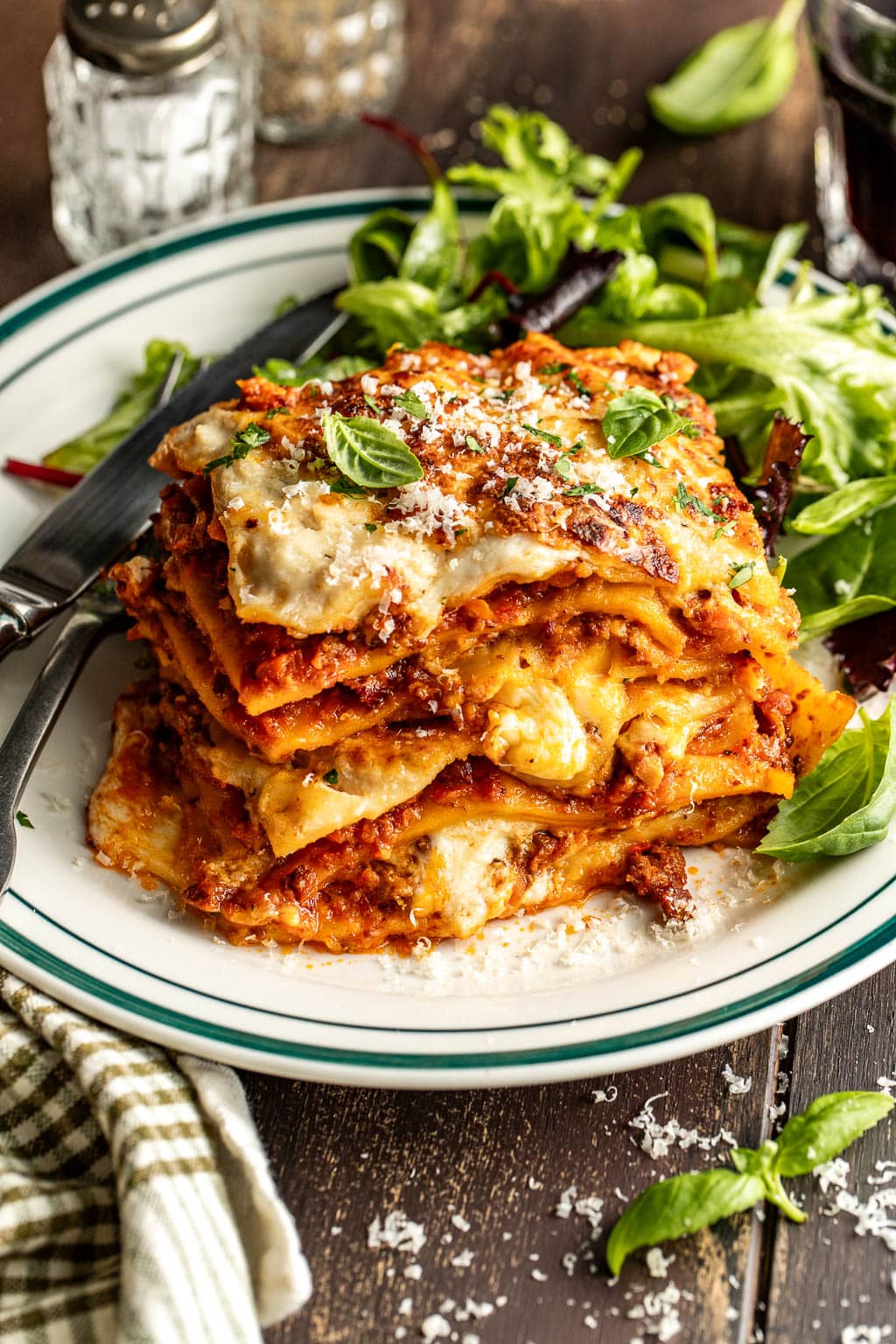 lasagna bolognese on a plate with salad