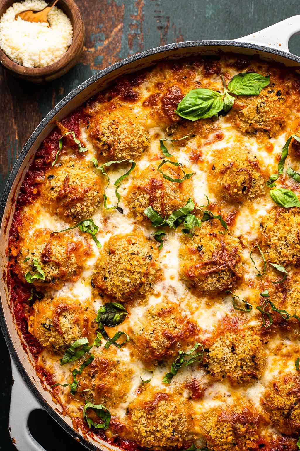 Baked chicken parm meatballs in a skillet. 