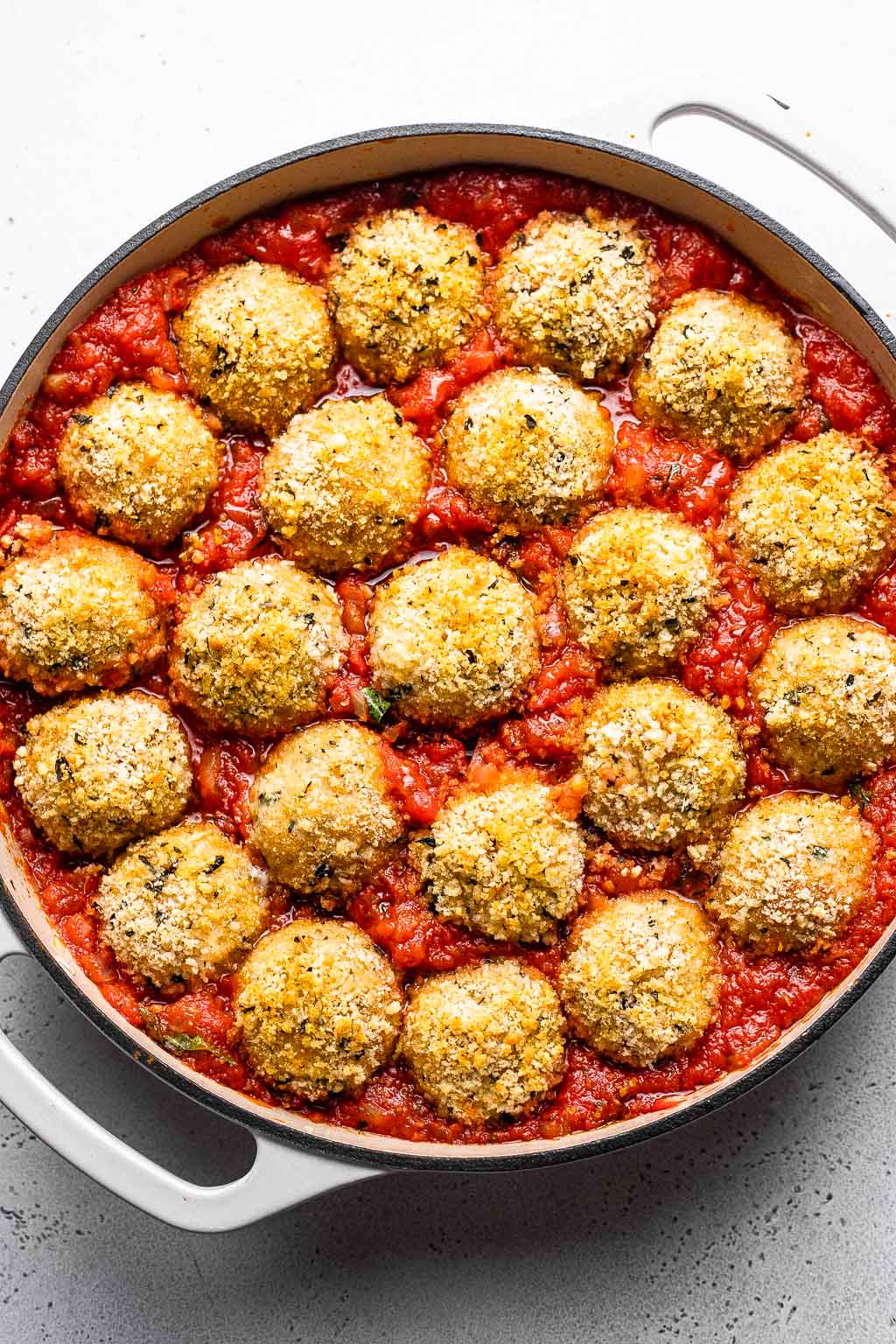 Meatballs in marinara sauce, ready to be baked. 