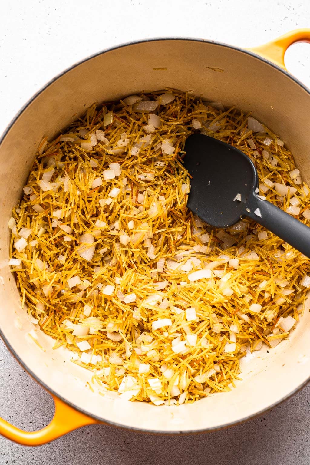 toasting fideo noodles and onion in a dutch oven 