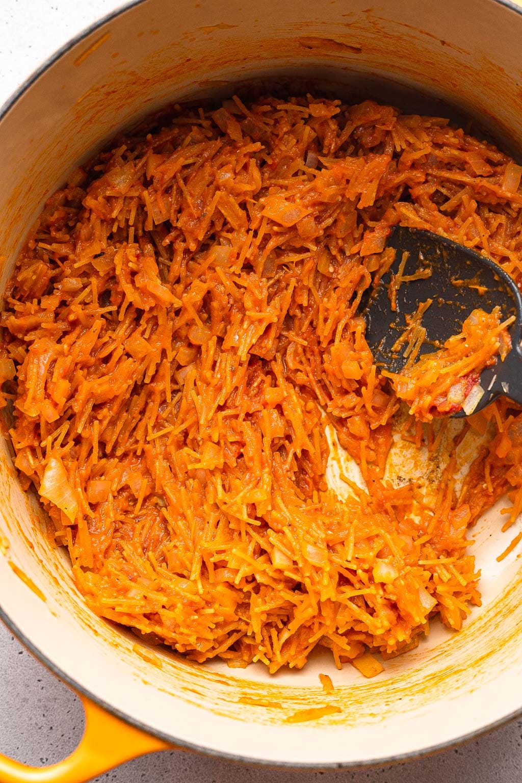 fideo and tomato paste toasting in a dutch oven 