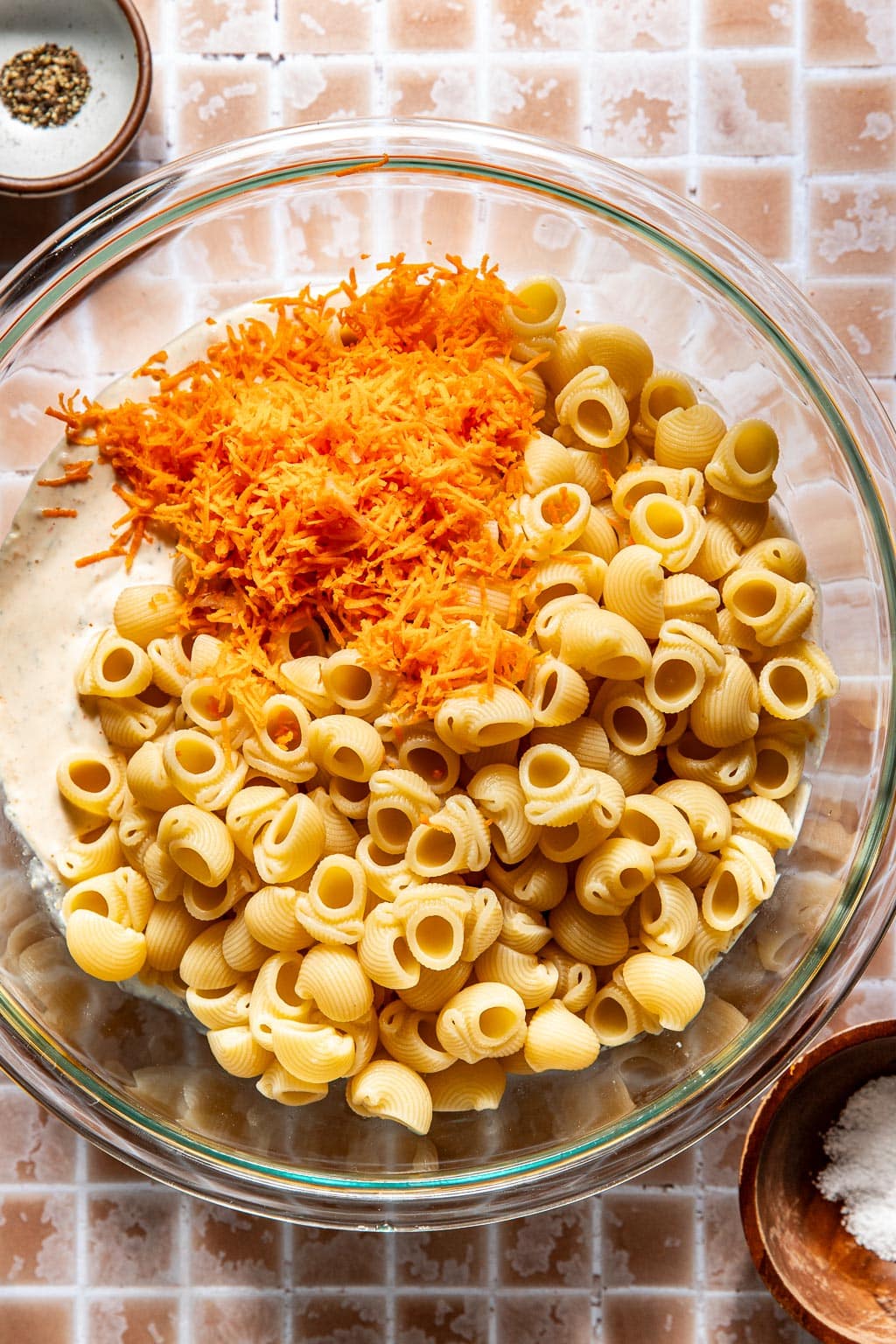 mixing the pasta and grated carrots into the dressing