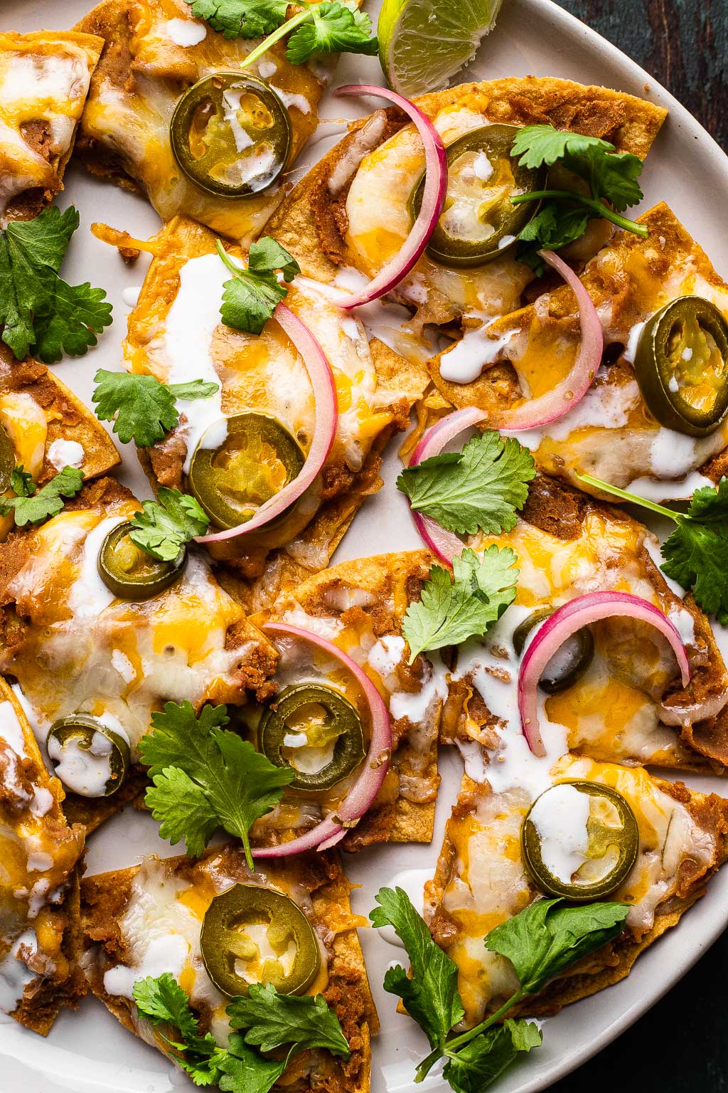 Texas Nachos topped with onion, cilantro, and crema