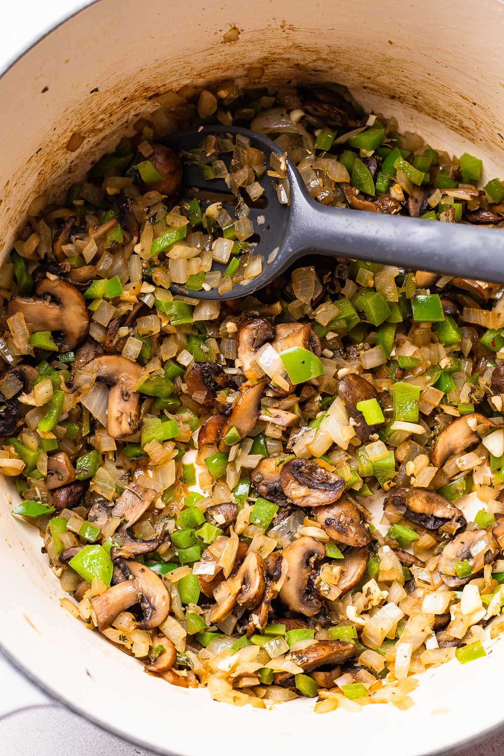Veggies and aromatics being sauteed in a dutch oven 