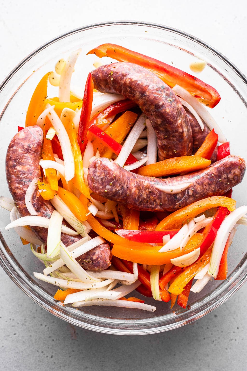 Raw Italian sausage, peppers, and onions in a mixing bowl 