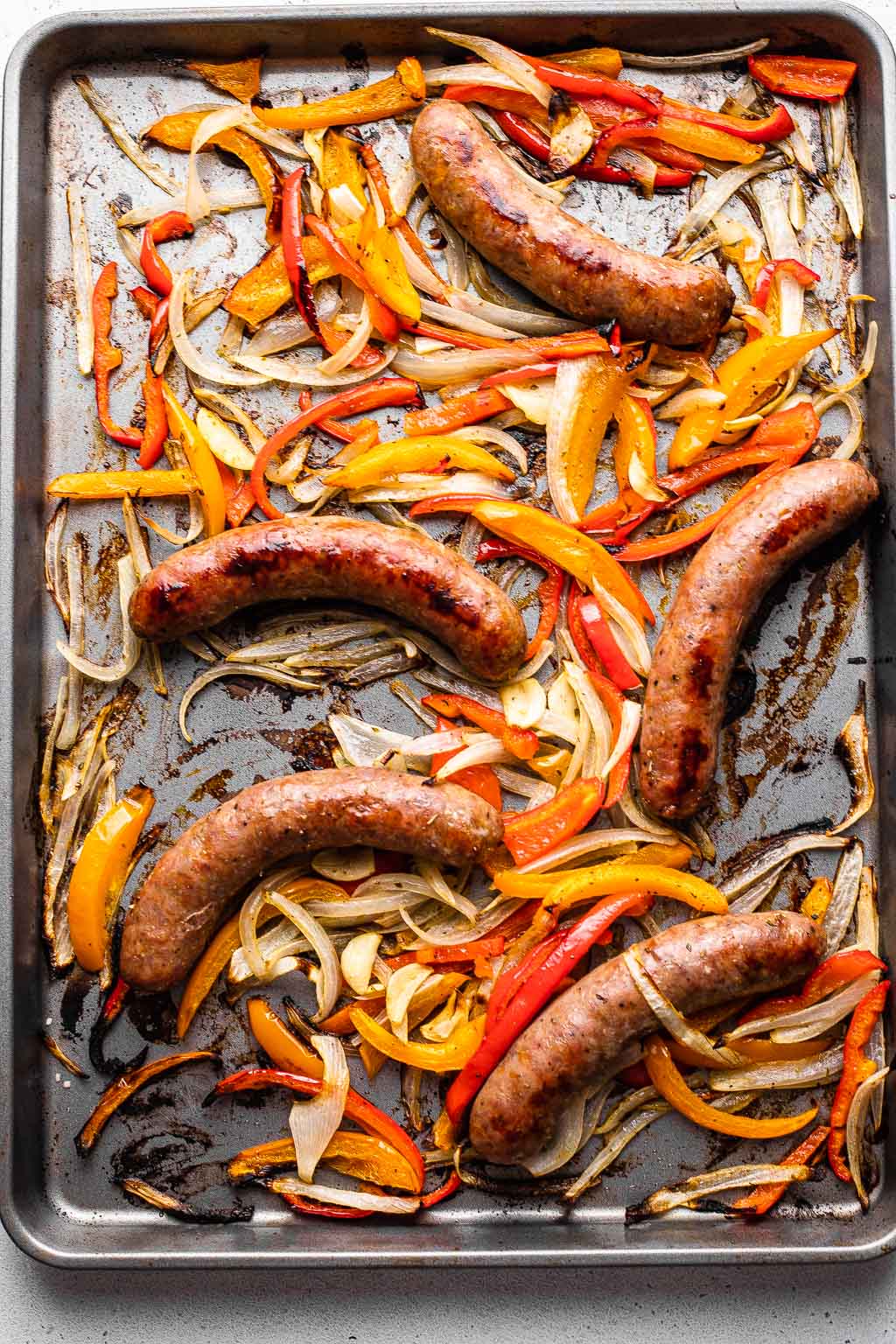 Italian sausage, peppers, and onions on a sheet pan 
