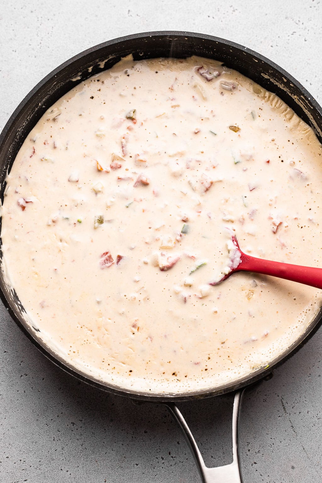 white queso being simmered in a skillet 