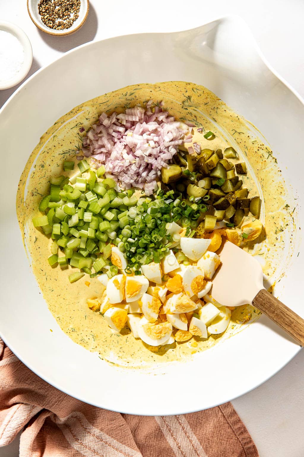 Potato salad dressing and mix ins in a mixing bowl