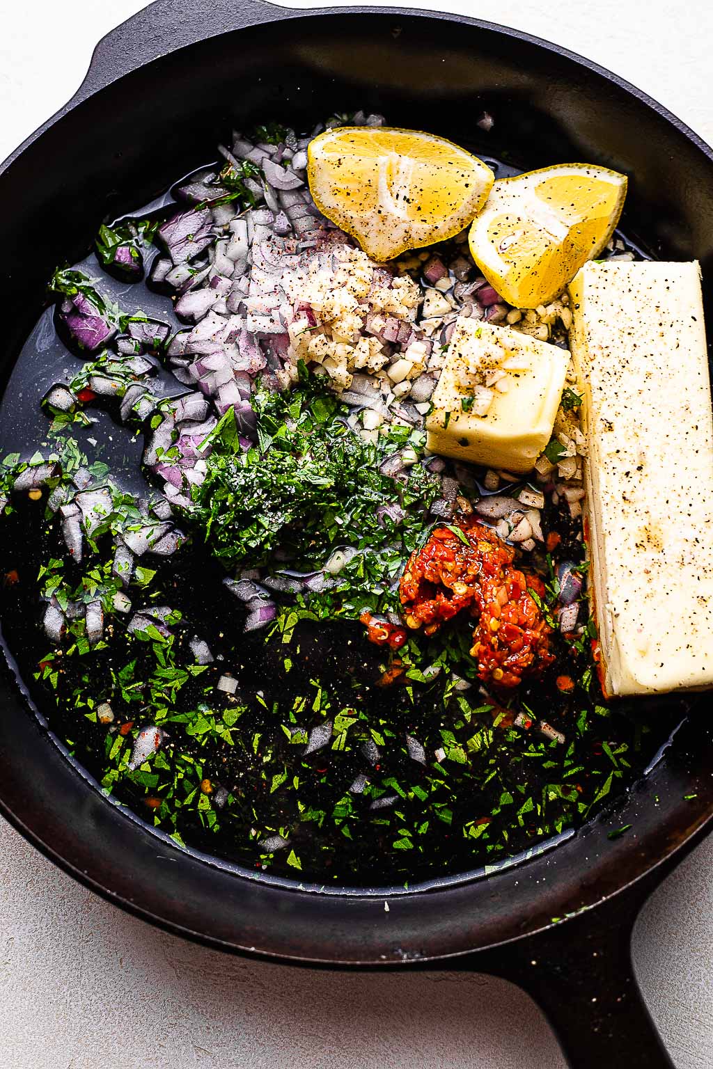 Ingredients for butter sauce in a cast iron skillet