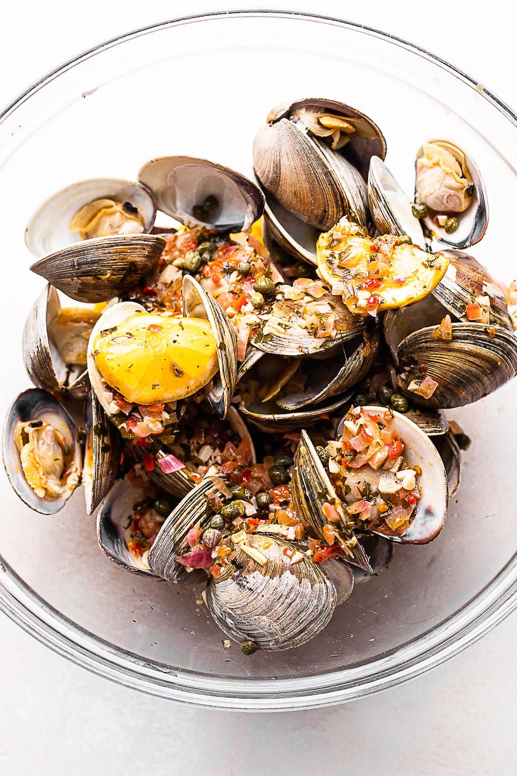 Grilled clams being tossed with butter sauce 