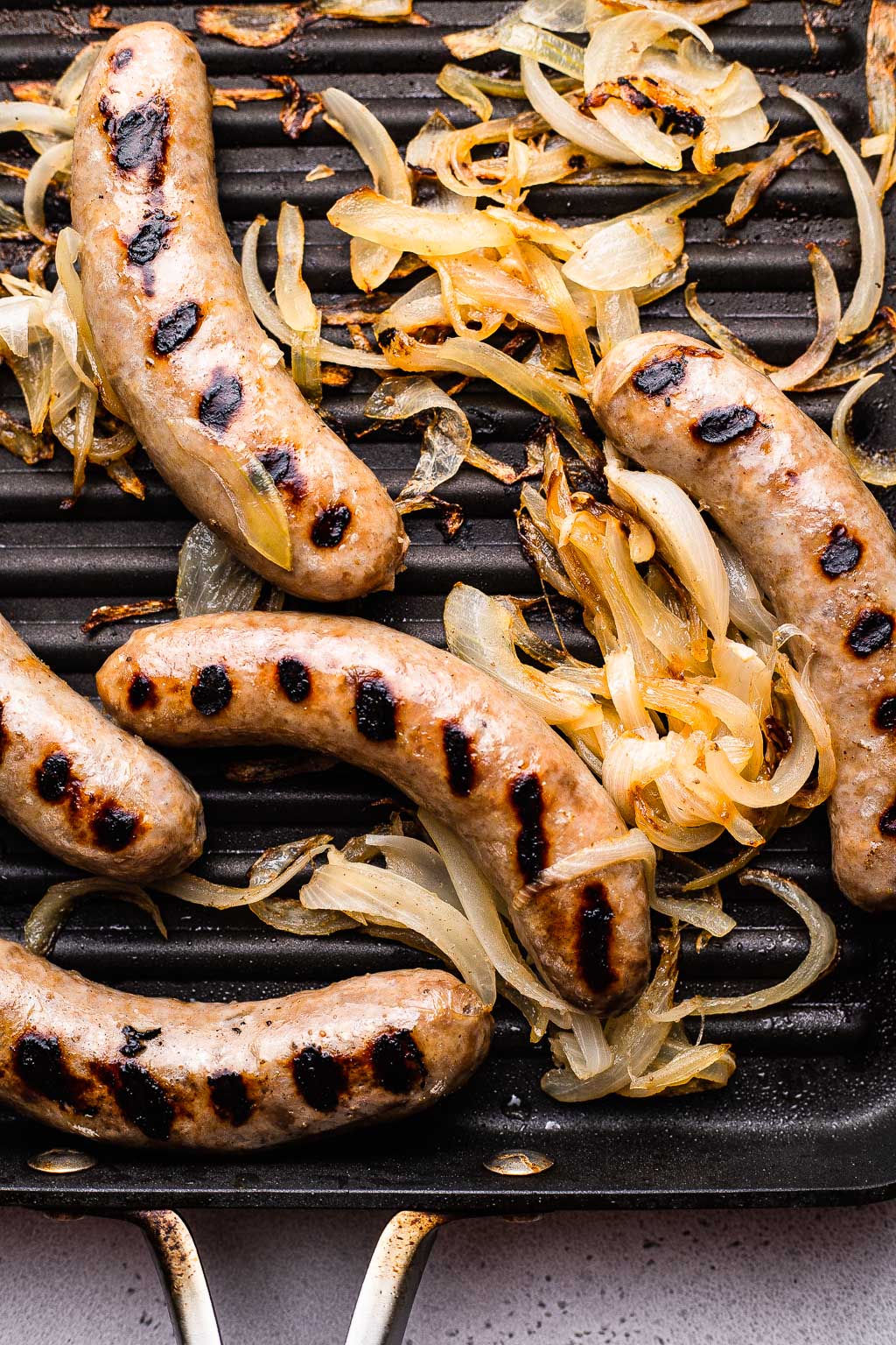 Brats grilling with onions 