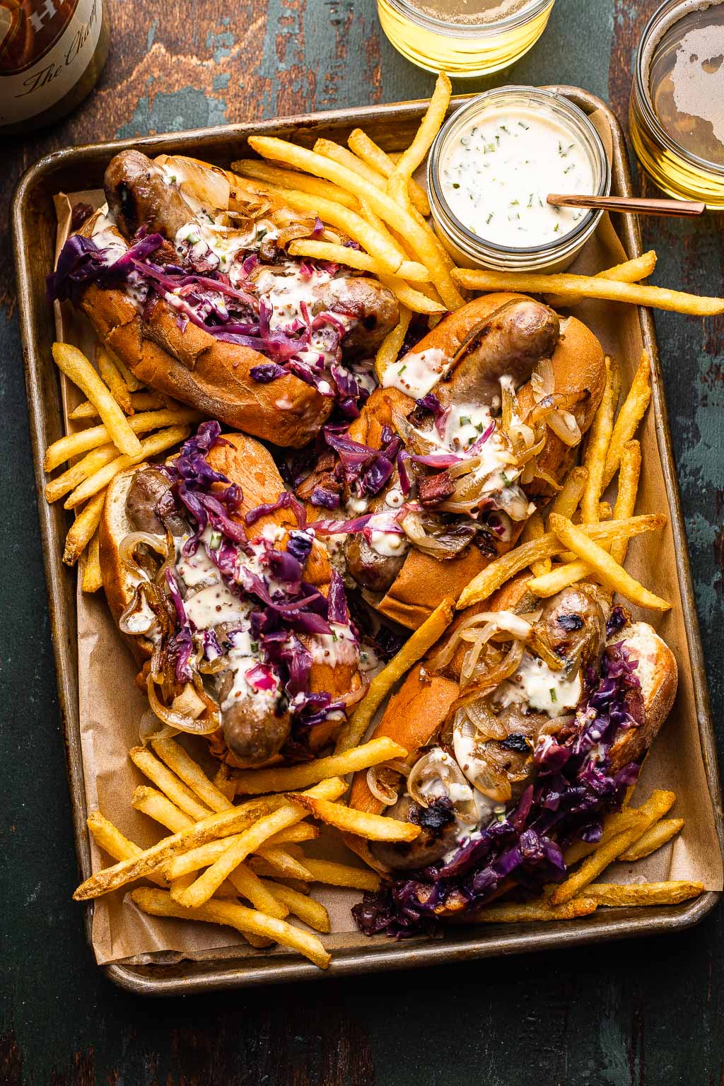 Wisconsin-style grilled beer brats on baking sheet with fries 
