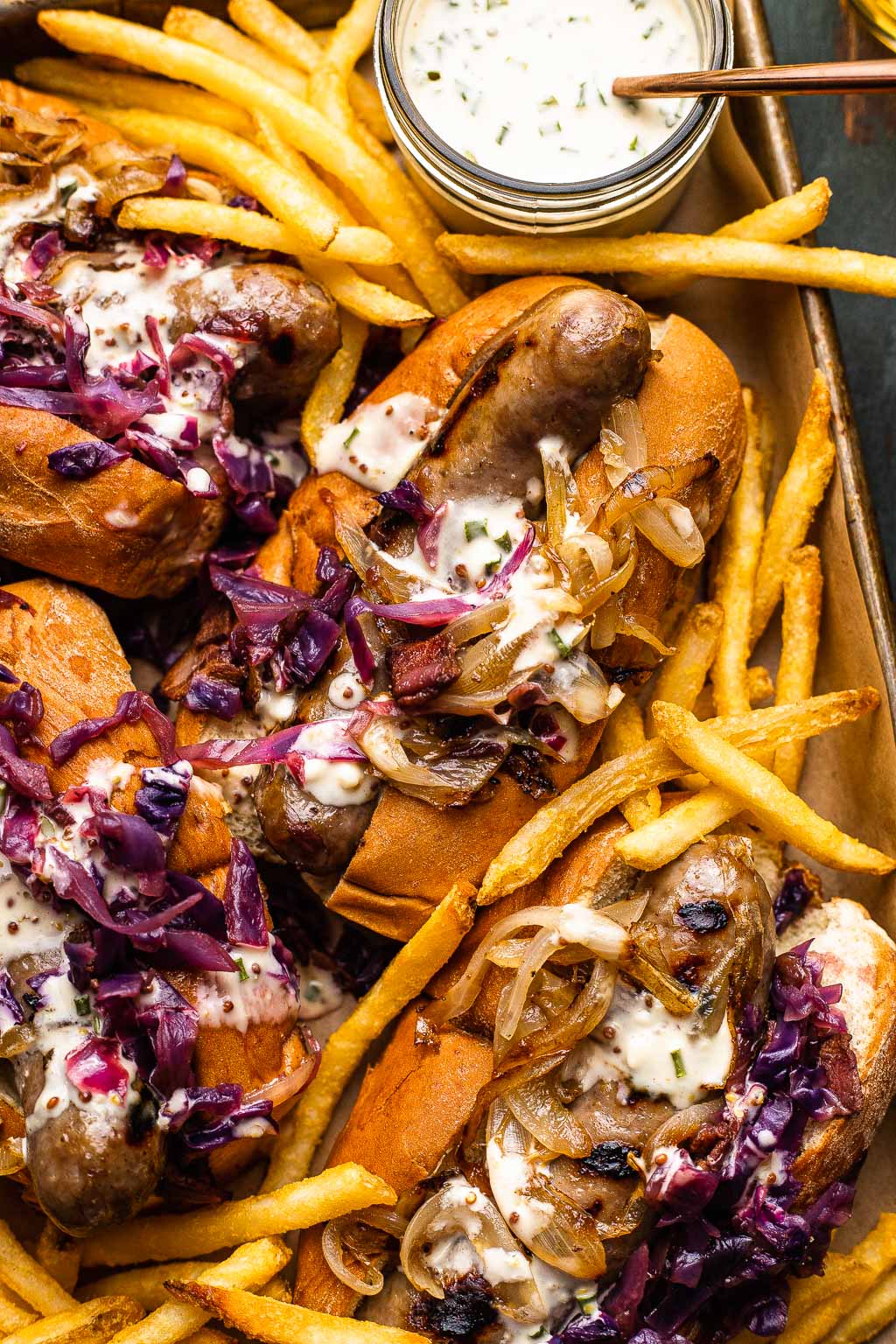 beer brats on a baking sheet with french fries