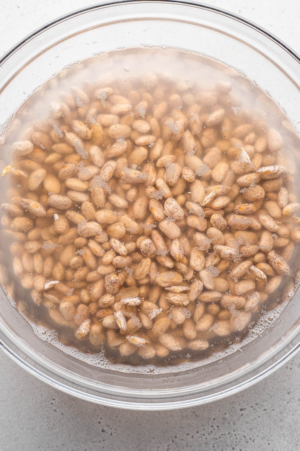dried beans soaked in a bowl of water 
