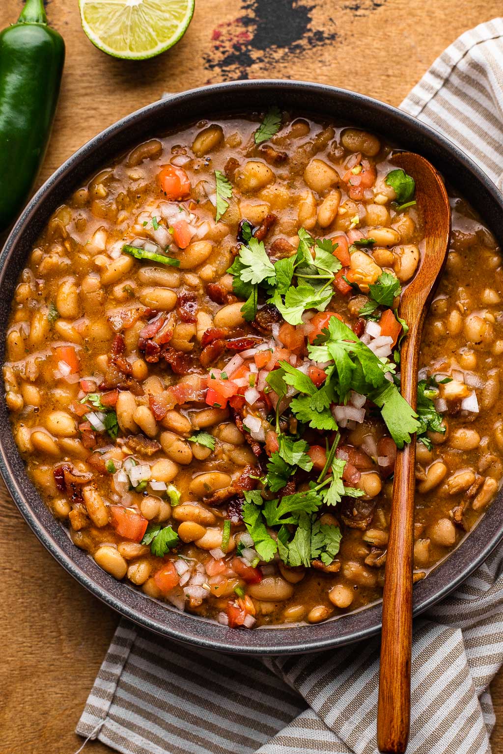 frijoles borrachos in a serving bowl with spoon 