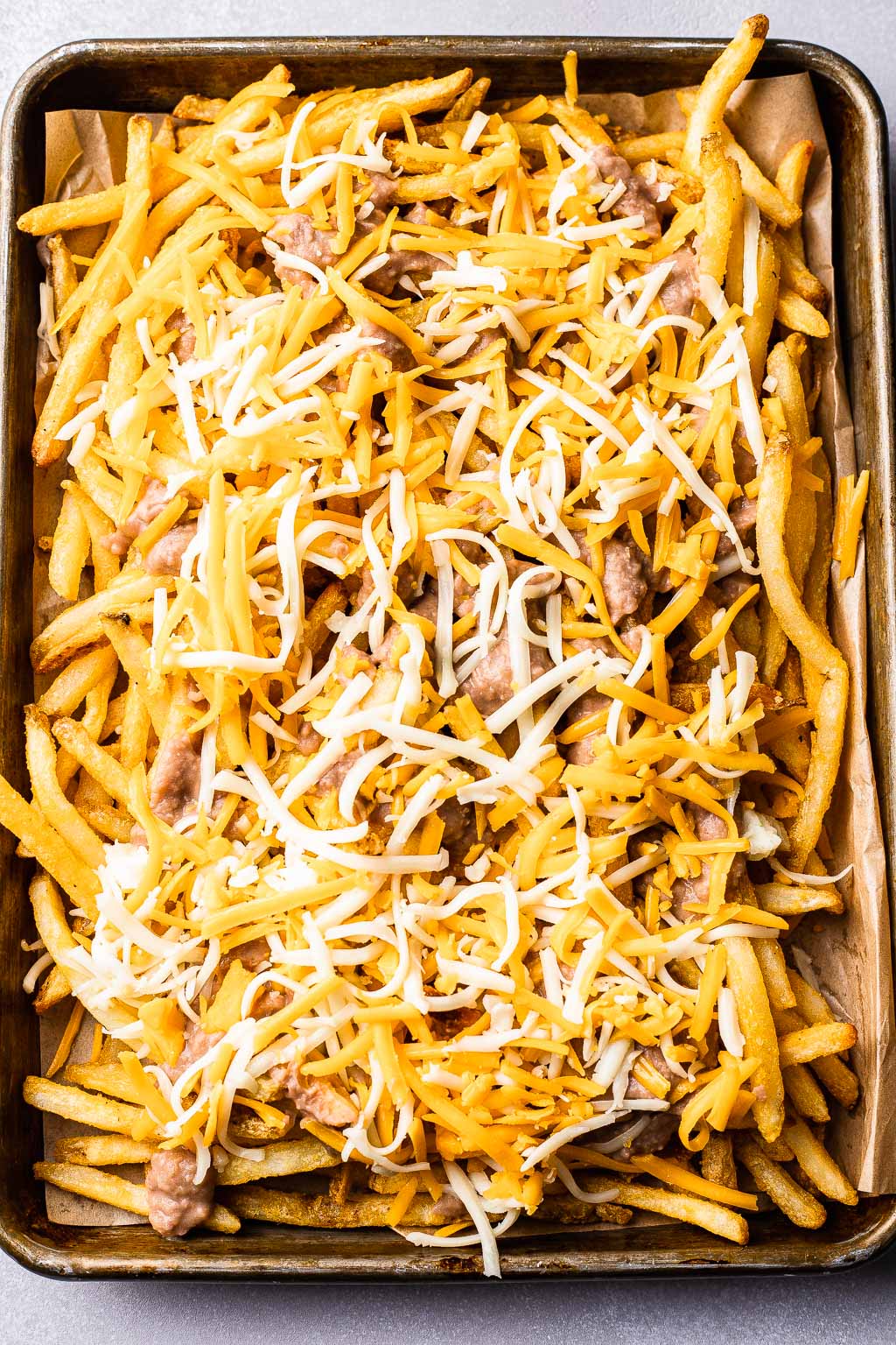 French fries topped with refried beans and cheese 