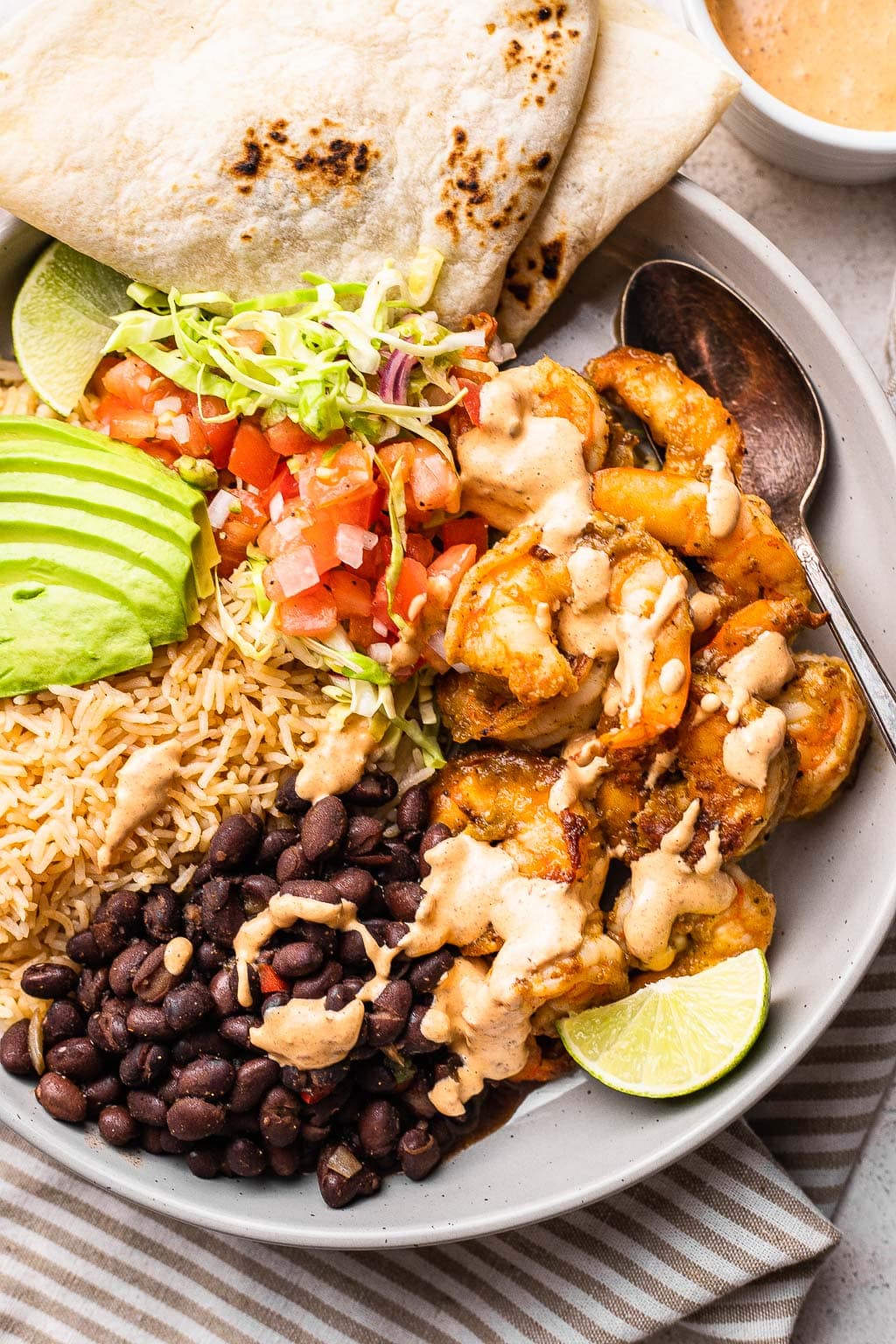 A shrimp burrito bowl topped with chipotle sauce 