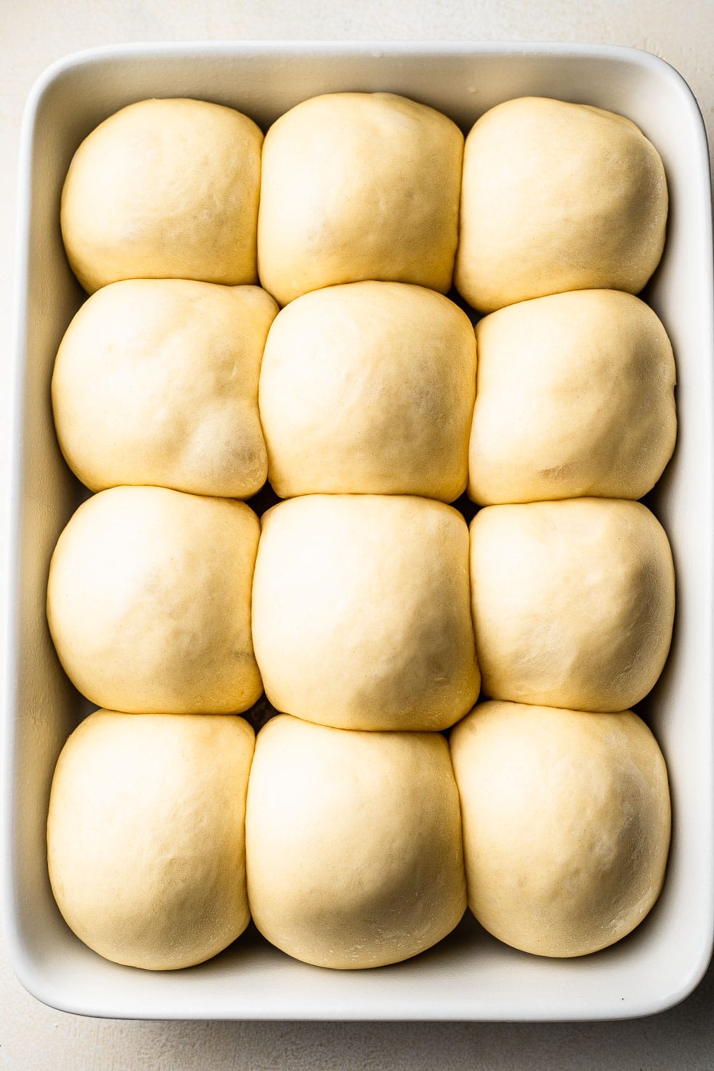 Unbaked brioche rolls in a baking dish 