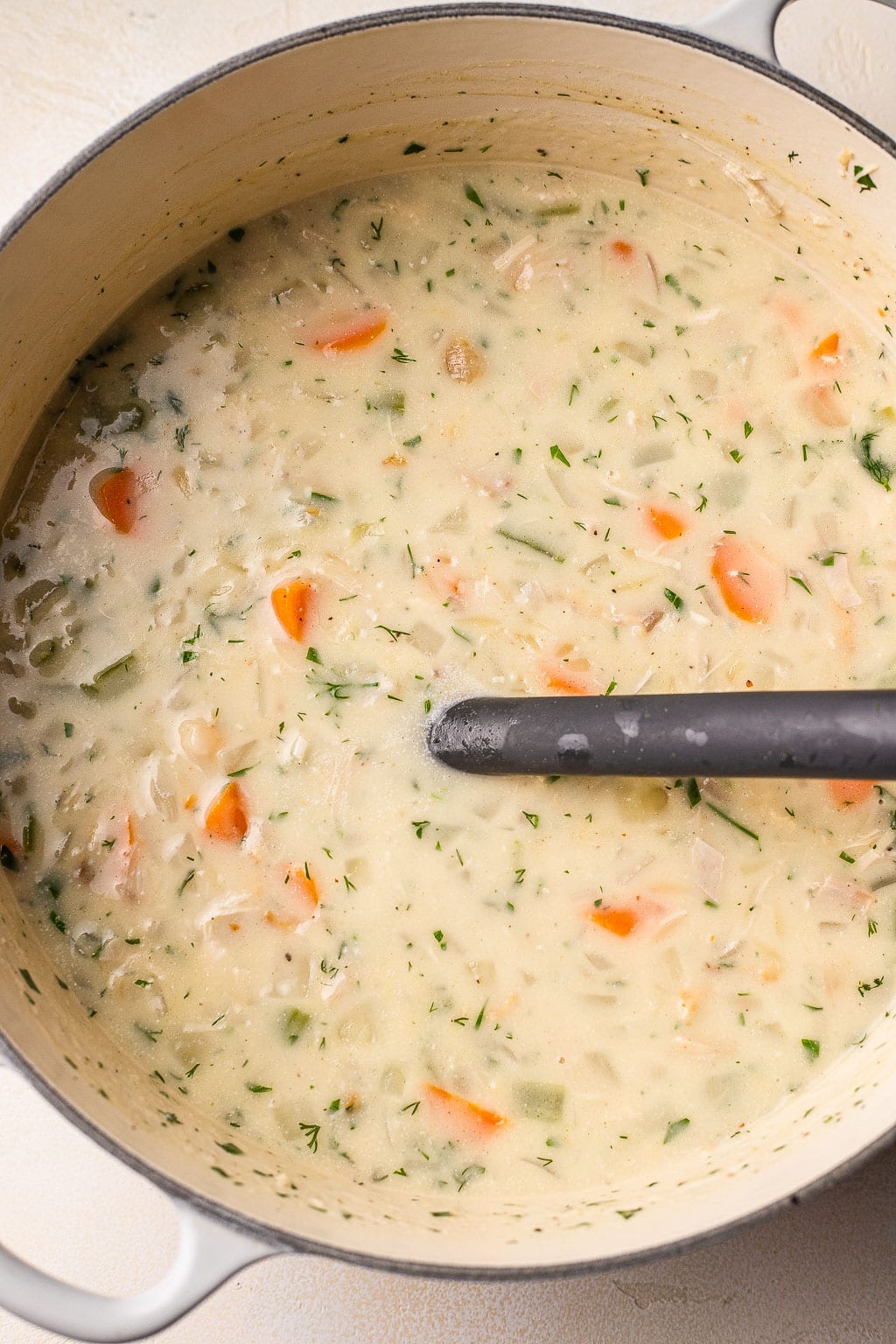Creamy chicken and orzo soup in a pot 