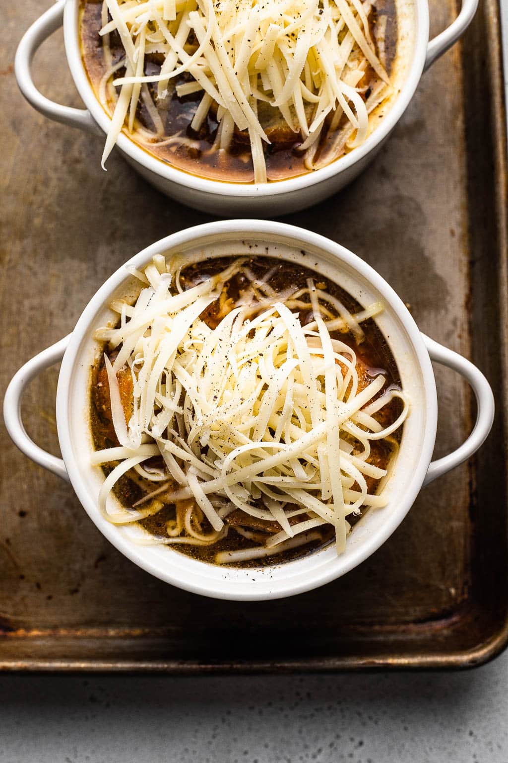 French onion soup ready to be broiled to melt the cheese. 