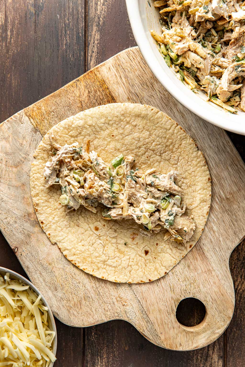 turkey filling in a flour tortilla before rolling it up