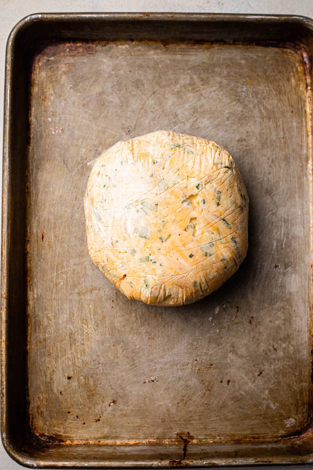 Cheese ball mixture wrapped in plastic wrap 