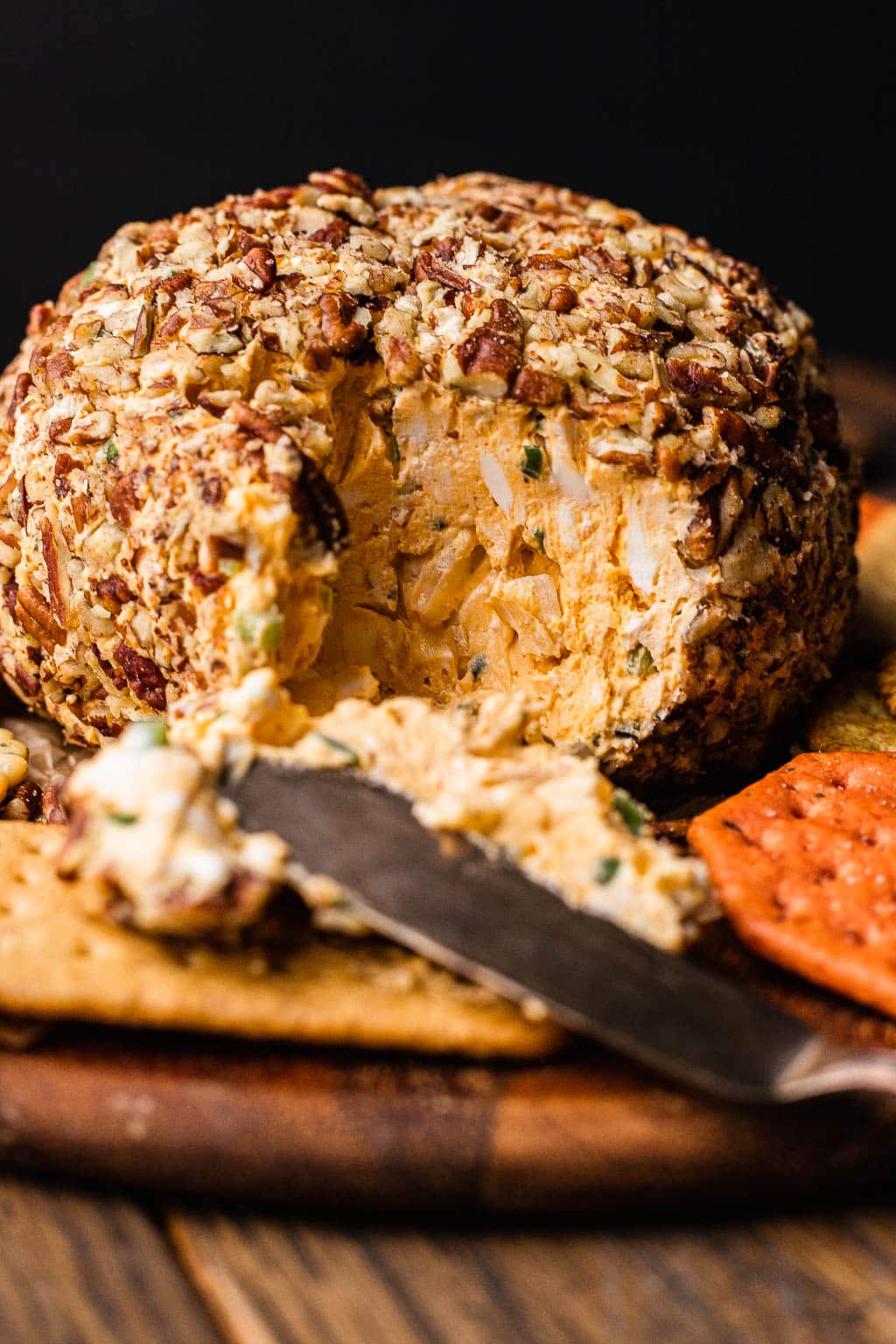 A pecan-coated cheddar cheese ball, split open to show inside