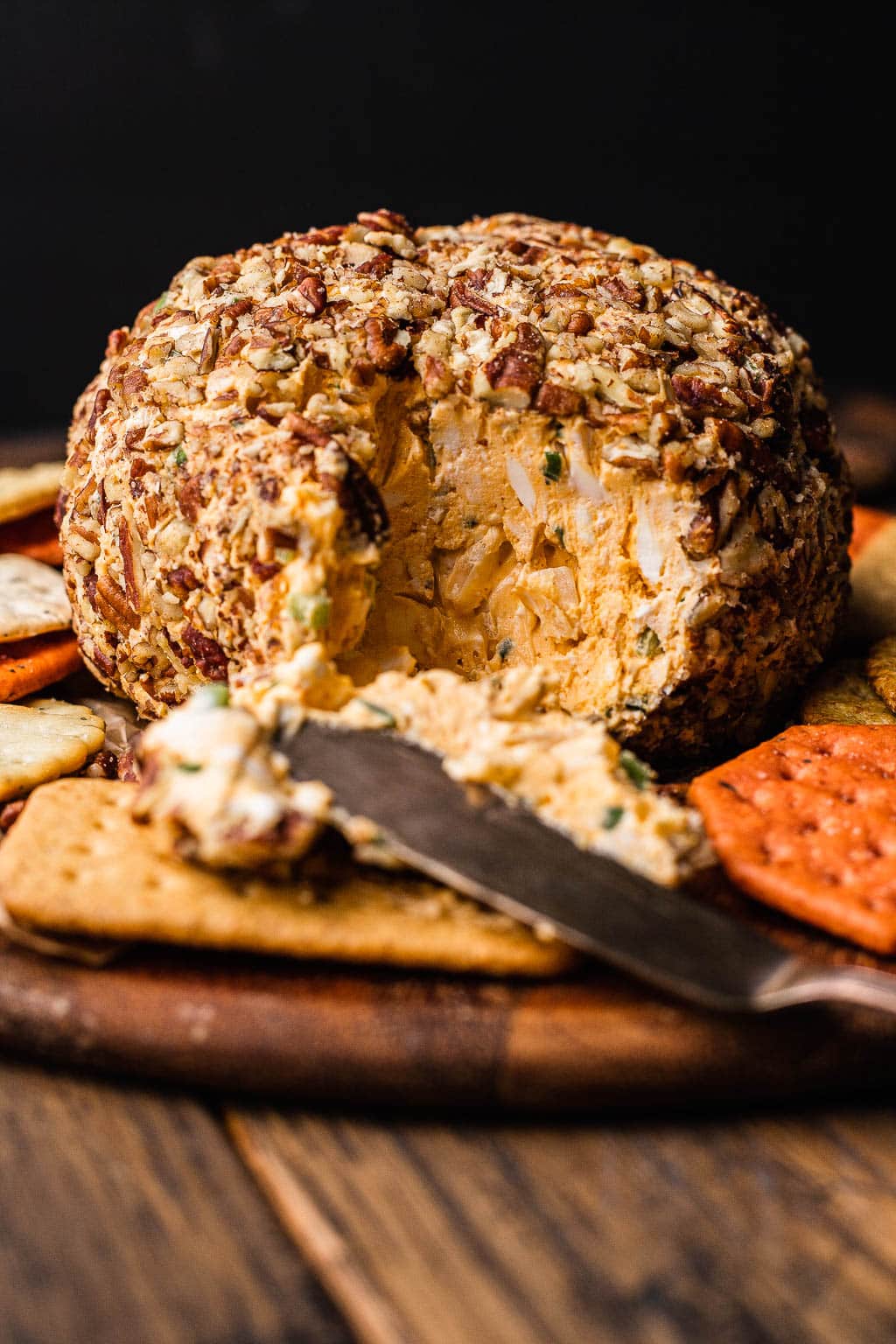 A pecan-coated classic cheese ball, split open to show inside