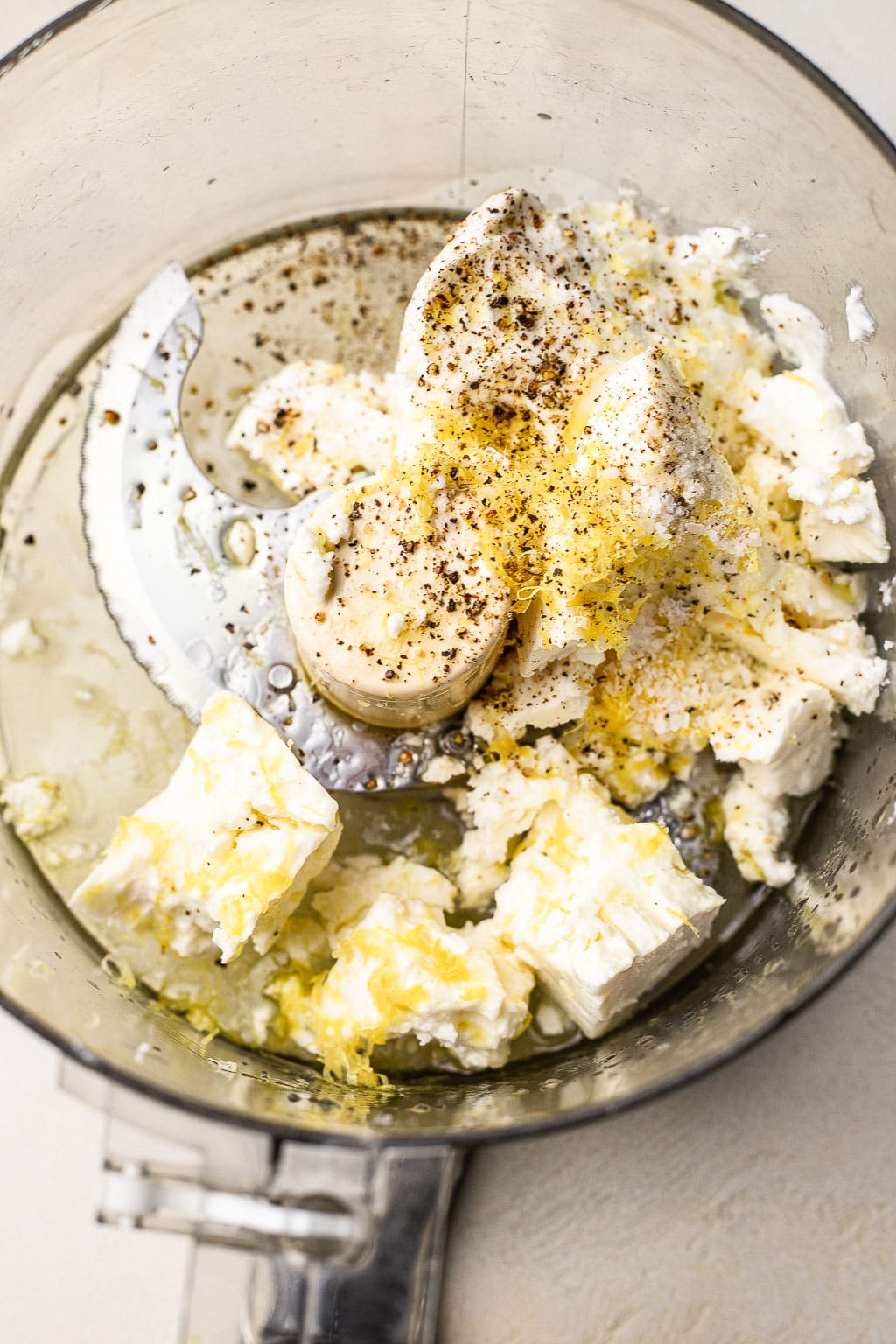 Block of feta crumbled into a food processor 