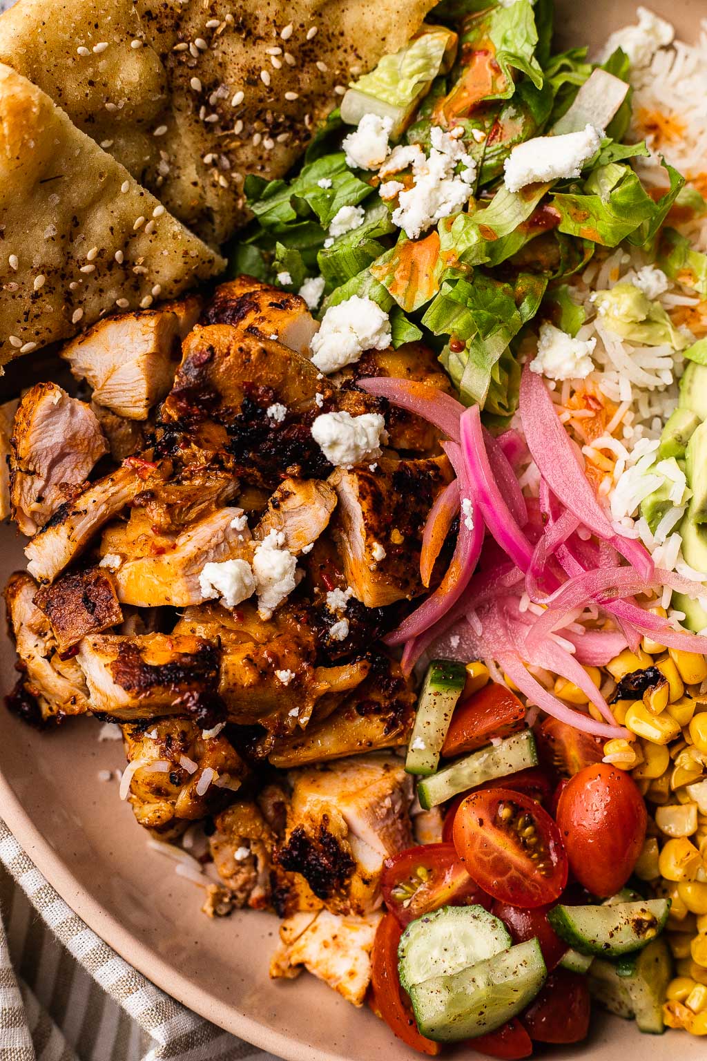 A close up view of harissa chicken in a rice bowl 