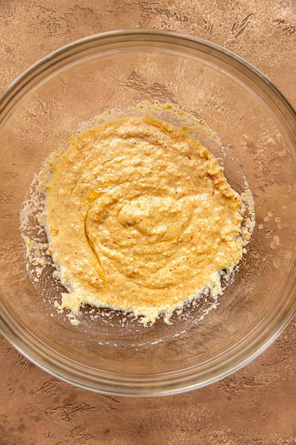 Breadcrumbs hydrating in a mixing bowl with eggs and milk 