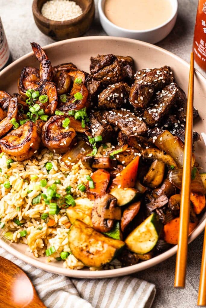 a steak and shrimp hibachi bowl over fried rice