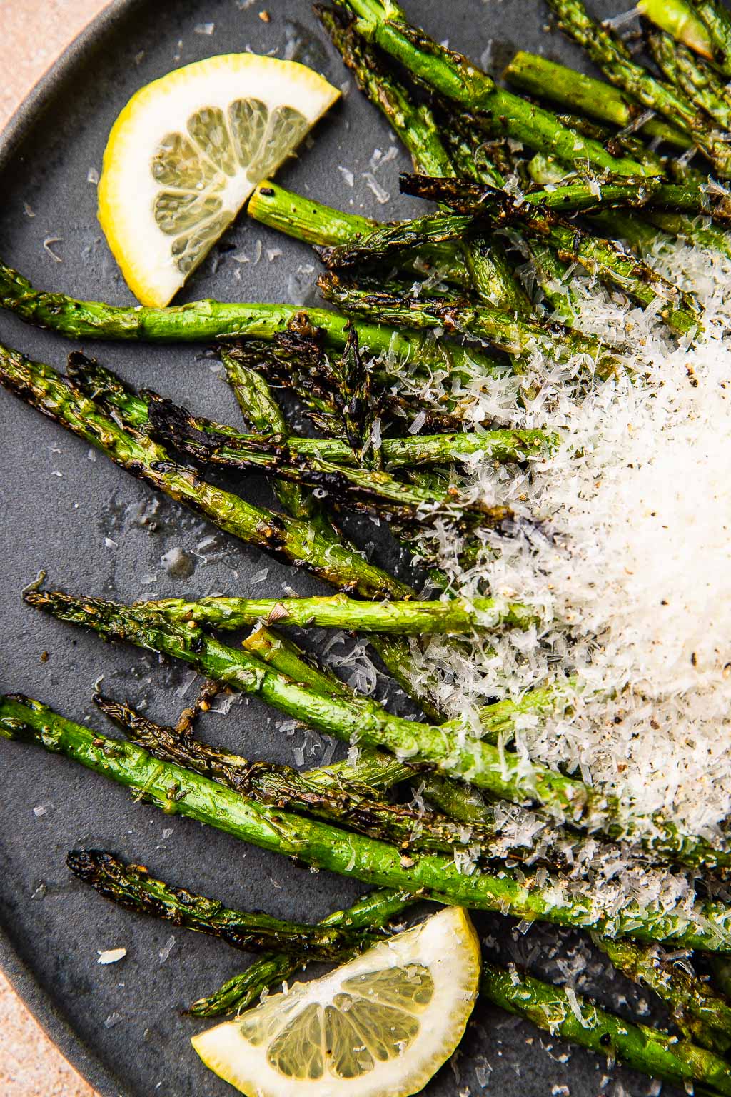 A plate of grilled asparagus topped with grated parmesan