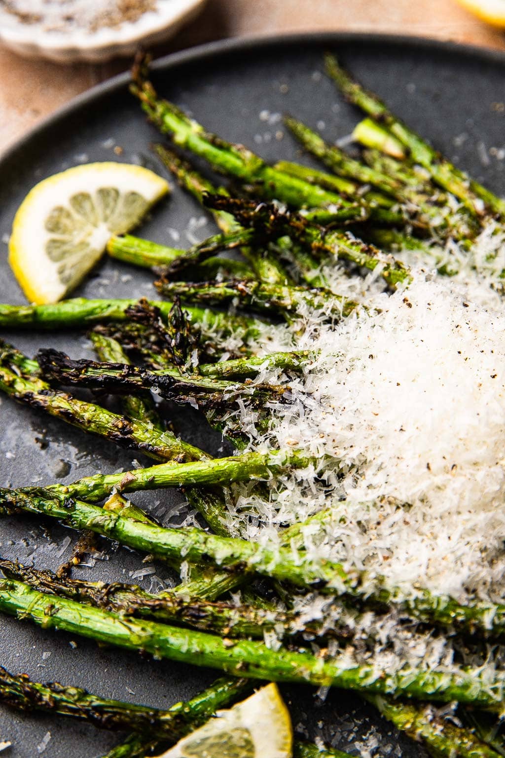 A plate of grilled asparagus topped with grated parmesan