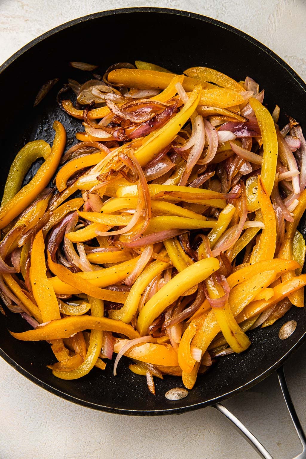 Sautéed peppers and onions in a skillet. 