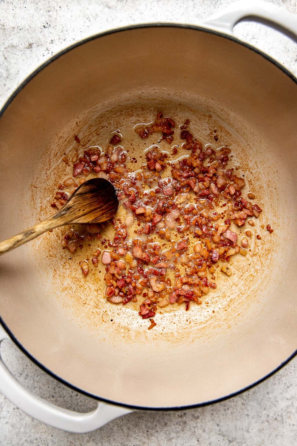 Pancetta crisping up in a Dutch oven 
