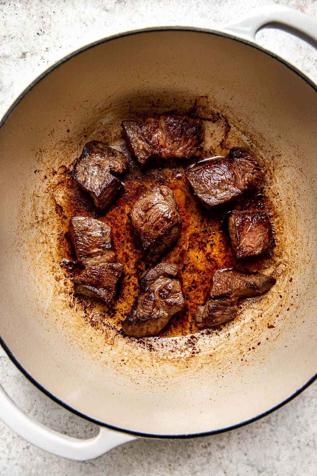 Beef chuck being seared in a Dutch oven 