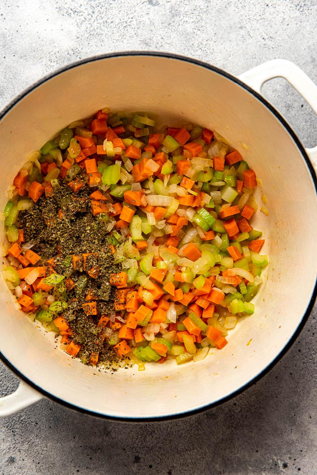 Celery, onions, carrots, and herbs in a Dutch oven 