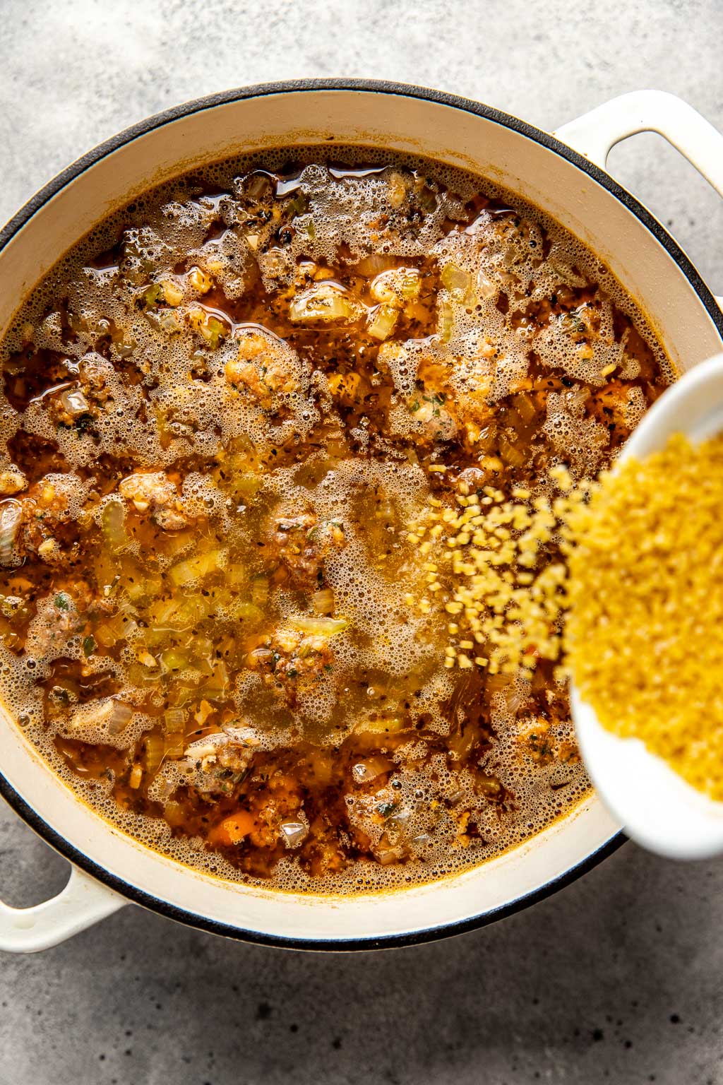 Pastina being added to Italian wedding soup 